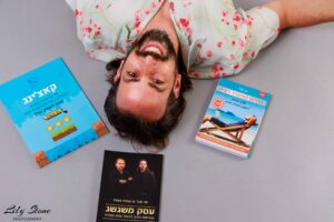 תמונה של גבר מחייך ומרוצה עם שלושה ספרים על נושא מכירות ושיווק, לקידום מכירות והצלחה עסקית.