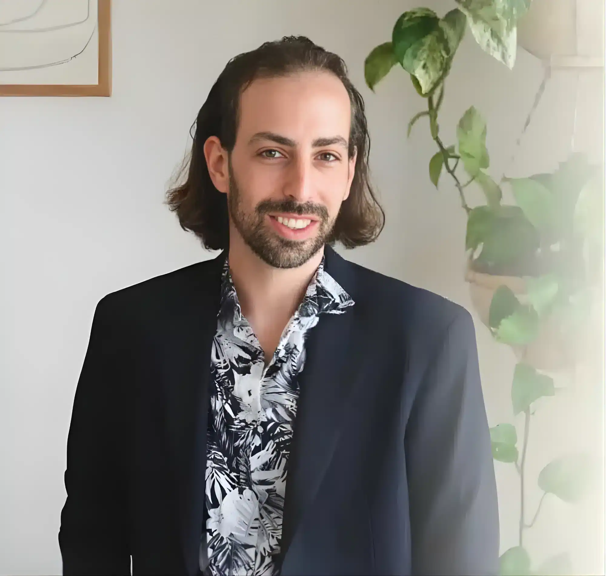 שף פרטי מקצועי עם חיוך, לובש חליפה, בסביבת בית מודרנית.